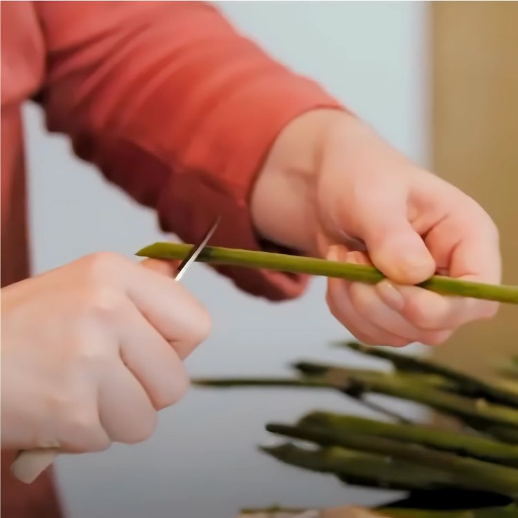 Person cutting flower stems at an angle