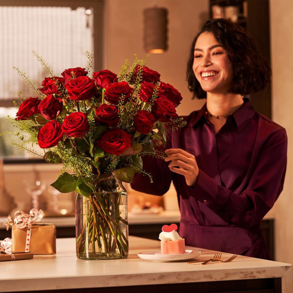 A woman in Amsterdam enjoying a beautiful bouquet of red roses