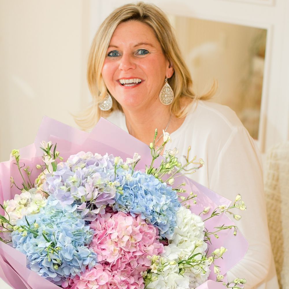 A happy woman proudly holding her delivered bouquet of red roses in The Hague